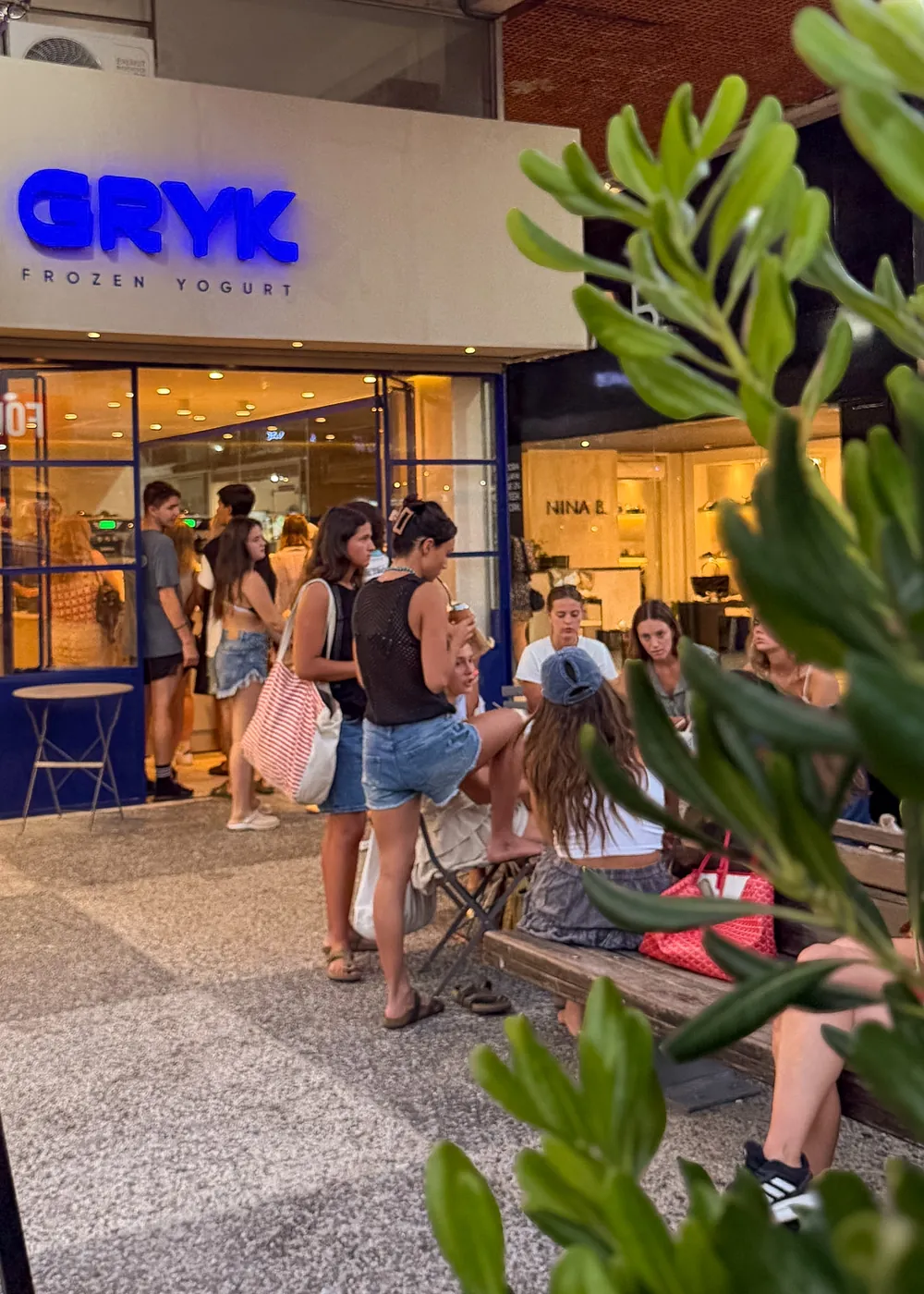 Gente en la puerta de GRYK en Gorlero, de noche